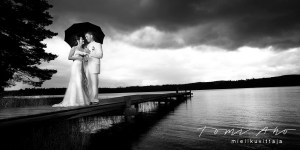 hääpari seisoo laiturilla, sateenvarjo käsissään, taivas on musta. Keuruun Isossa kirjassa laiturilla kuvattu hääkuva oli harvoista hääparille ulkona kuvatuista kuvista rankkasateen vuoksi. Musta taivas oli dramaattinen ja loi kontrastia hääparin lempeydelle.