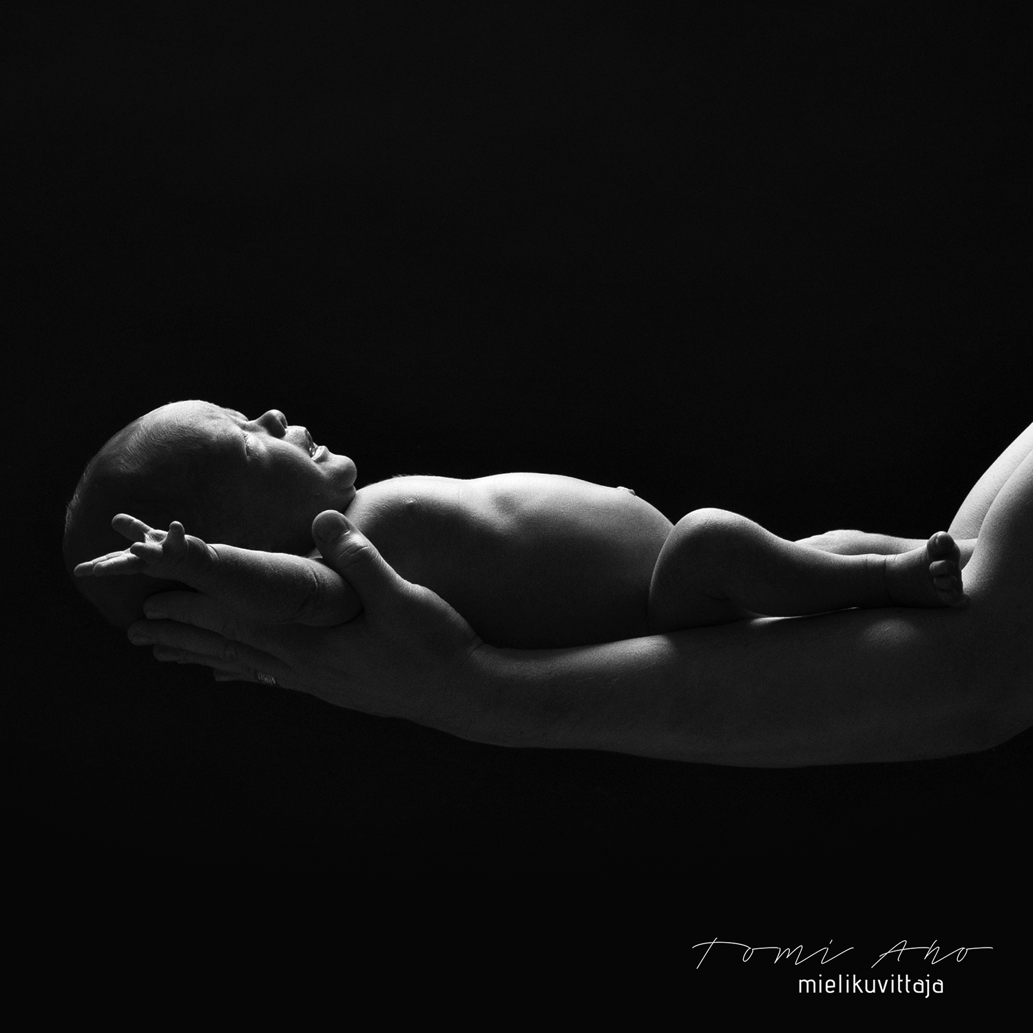 Studiokuvaus vauvasta isän käsivarsilla valokuvaaja Tomi Ahon toteuttamana