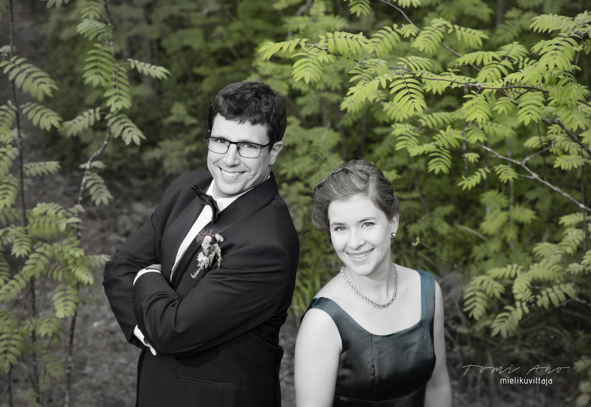 Sävytetyssä hääpotretissa sulhanen ja morsian hymyilevät valokuvaaja Tomi Aholle.