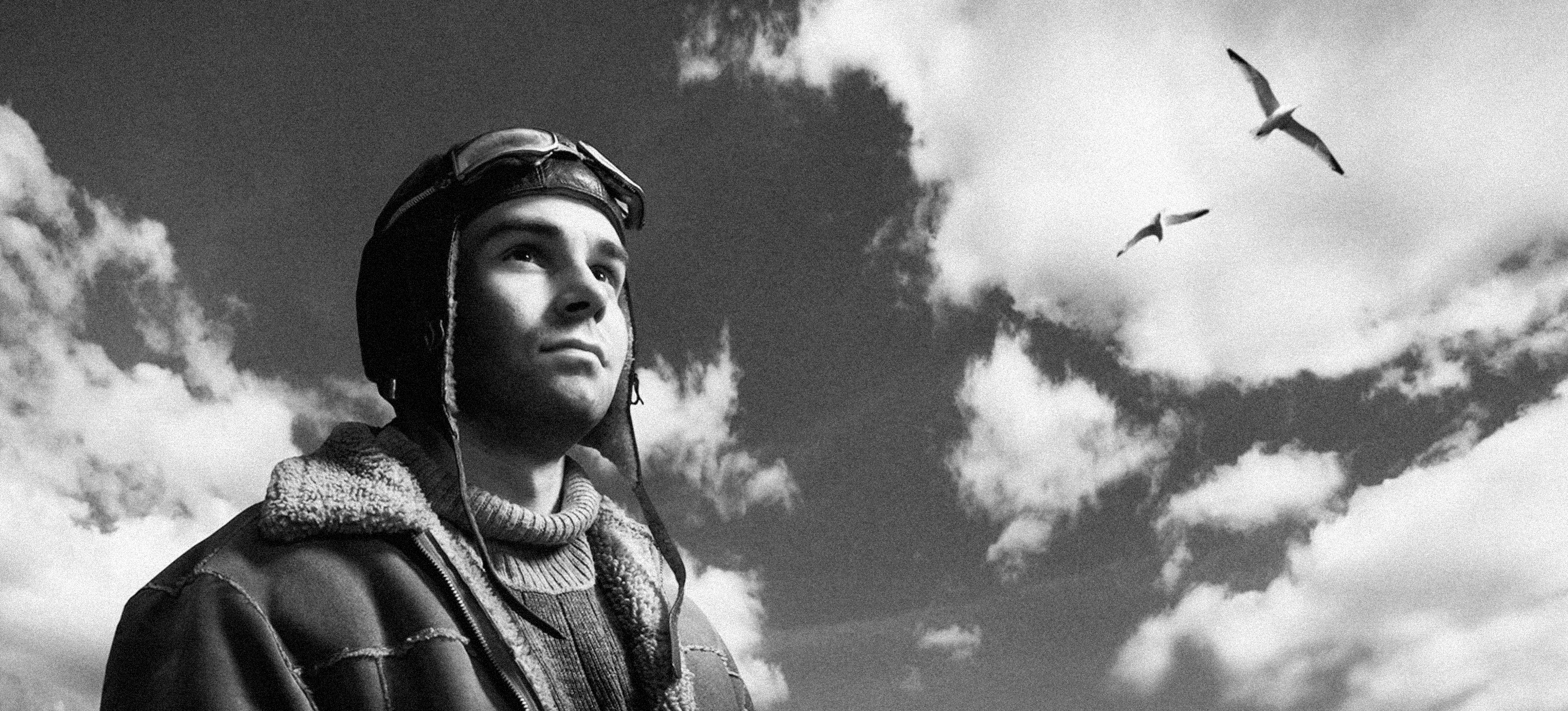 Taidemuotokuva lentäjästä, taustalla taivas ja lokkeja lentämässä. Mielikuvittaja Tomi Aho