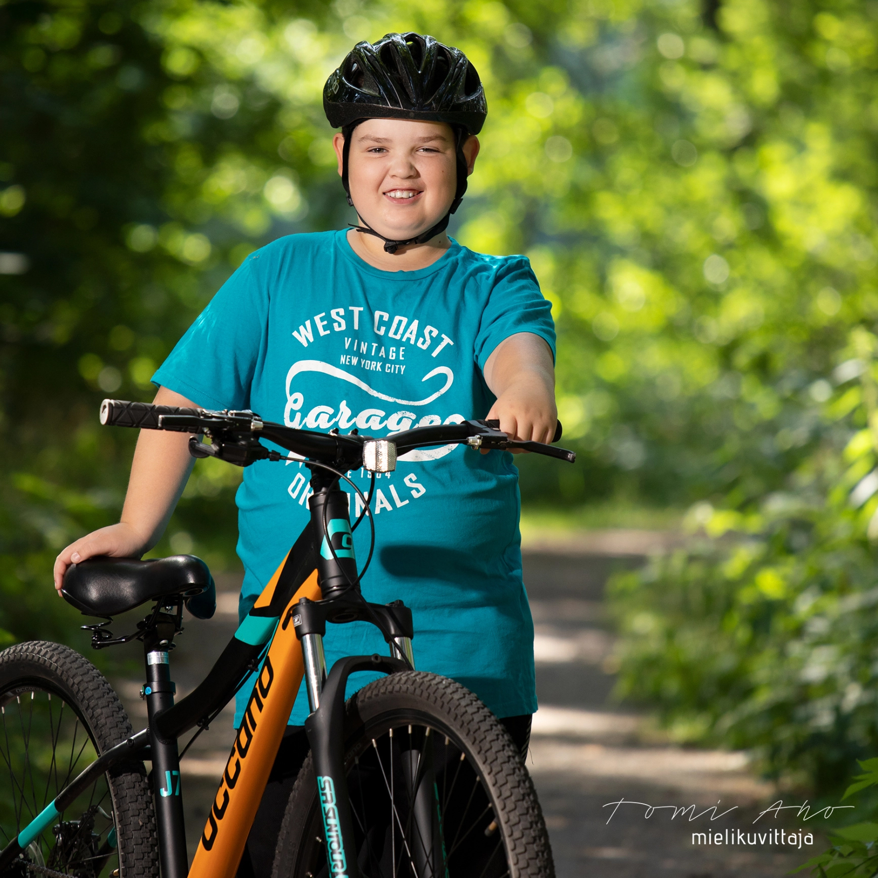 Nuori poika hymyilee muotokuvassa uuden pyörän äärellä Mielikuvittaja Tomi Aho