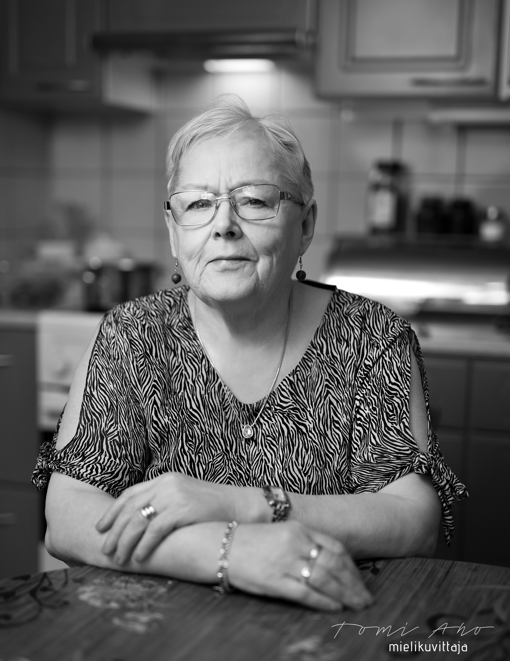 Mustavalkoinen muotokuvaus lempeästä iäkkäästä naisesta Mielikuvittaja Tomi Aho.