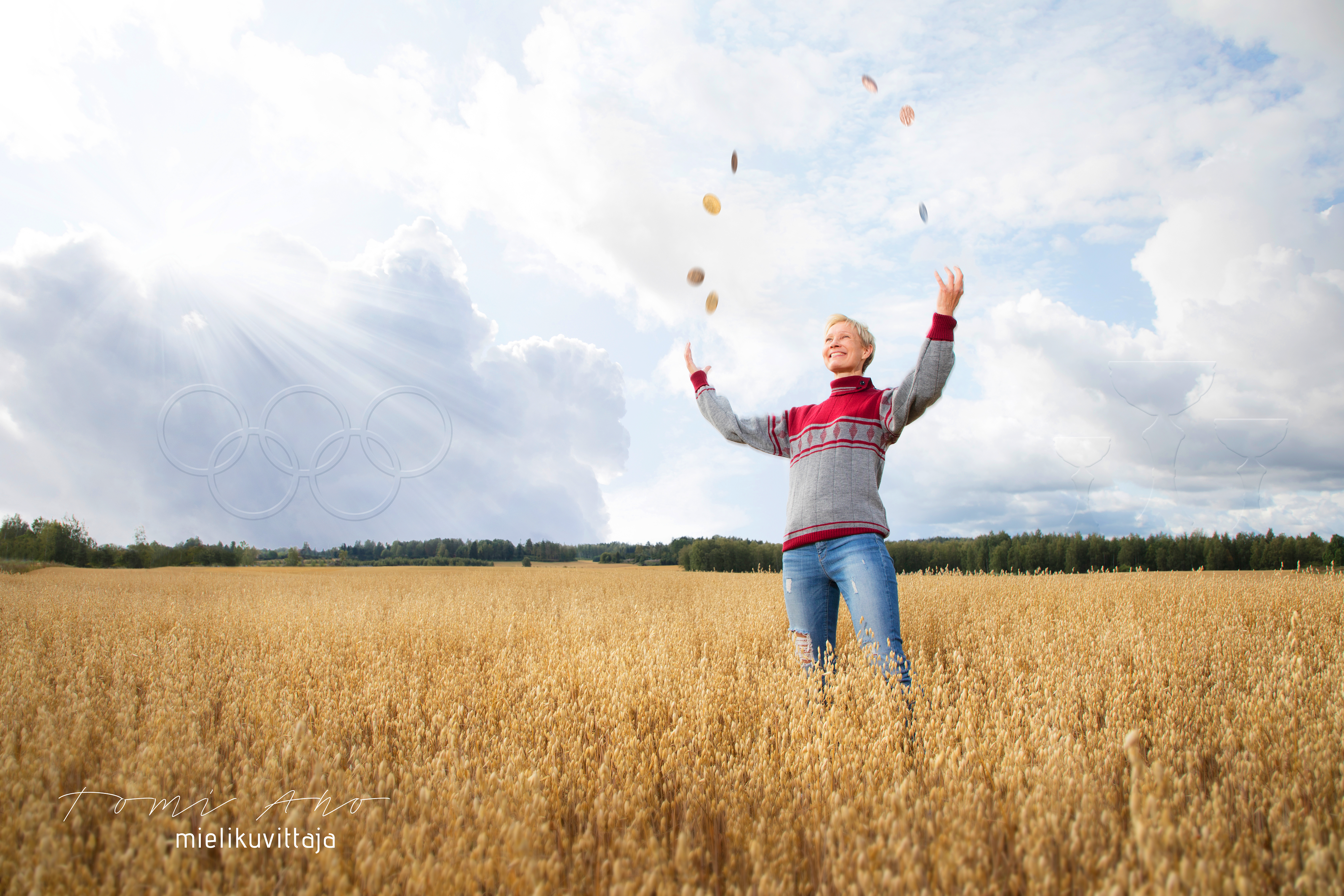 Olympialaisissa hiihtänyt hiihtäjä Annmari Viljanmaa jonglööraa mitaleilla pellolla Mielikuvittaja Tomi Ahon kuvassa.
